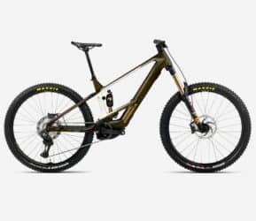 # Revisión Orbea Wild 2026 La **Orbea Wild 2026** es, sin ninguna duda, una de las bicicletas eléctricas de montaña más esperadas del año, fruto de una evolución constante y de una clara apuesta de la marca vasca por el alto rendimiento, la tecnología de vanguardia y la personalización extrema. En esta *revisión Orbea Wild 2026* te traigo un análisis exhaustivo sobre sus novedades, geometría, motores, versiones, configuraciones y sensaciones en el trail, profundizando en lo que realmente importa a quien busca una e-enduro radical, pero versátil y lista para cualquier desafío. --- ## Introducción: El renacimiento de una leyenda eléctrica Hablar de la **Orbea Wild** es hablar de un mito en el universo e-MTB. Tras ganar los principales comparativos y premios internacionales durante los últimos años, la Wild necesitaba responder a la llegada de nuevos motores, rivales cada vez mejor armados y la mayor exigencia de los bikers de enduro eléctricos. Orbea no ha decepcionado: la nueva Wild 2026 no solo actualiza, sino que reinventa gran parte de su propuesta integrando lo mejor de Bosch, refinando detalles clave y abriendo el abanico de opciones de personalización a cotas extraordinarias [(ESMTB)](https://esmtb.com/la-orbea-wild-2026-se-actualiza-mas-potencia-y-mas-opciones/). --- ## Novedades clave de la Orbea Wild 2026 El salto respecto al modelo anterior va mucho más allá de un simple restyling. A continuación, desglosamos las innovaciones más resaltables: ### Motor Bosch Performance Line CX: Más potencia, modos avanzados y versión Race La gama Wild 2026 estrena compatibilidad con la última generación de motores **Bosch Performance Line CX**. Ahora, en sus versiones estándar puede alcanzar un par máximo de **100 Nm** y una potencia pico de **750 W**, todo configurable desde la aplicación Flow y ofreciendo niveles de asistencia de hasta el 400%. Para los más competitivos, llega el **Bosch Performance Line CX Race**, más ligero y pensado específicamente para el máximo rendimiento en enduro y E-EDR, montado de serie en las versiones tope de gama como la M-LTD y disponible como opción en otras. ### Nuevo display Bosch System Module Kiox 400C Las versiones **M10**, **M-Team** y **M-LTD** reciben el nuevo display Bosch Kiox 400C, integrado en el cuadro, mucho más informativo, intuitivo y personalizable. Visualiza datos en tiempo real con mayor claridad y puede instalarse en modelos anteriores con sistema Bosch [(ESMTB)](https://esmtb.com/la-orbea-wild-2026-se-actualiza-mas-potencia-y-mas-opciones/). ### Cambios de marcha Free Shift: tecnología Shimano XTR y XT Estreno de la función **Free Shift** en los montajes con Shimano XTR y XT, que permite cambiar de marcha sin pedalear. Ideal para anticipar desarrollos en pleno descenso o para resolver pasos técnicos donde no se puede aplicar potencia al pedal. ### Versiones en carbono y aluminio, y opción "mullet" El catálogo Wild 2026 arranca en las exclusivas versiones OMR Carbono (M-LTD, M-Team) con ruedas de 29", y expande las opciones con **versiones mullet** (29" delante, 27,5" detrás) configurables en todos los montajes. Las nuevas **Wild Hydro** de aluminio democratizan la Wild e-MTB desde 5.299€, y mantienen la radicalidad en geometría y motores sin sacrificar calidad ni tecnología. ### Geometría progresiva y más personalización MyO La Wild sigue apostando por una geometría agresiva, pero equilibrada: dirección a **63,5º**, tubo de sillín de **77,5º**, y longitudes de tubo corto para permitir el uso de dropper posts extralargos (hasta 240 mm). Todo ello sumado al potente configurador **MyO** de Orbea, que permite personalizar colores, suspensiones, ruedas, grupo, tijas, cubiertas e infinidad de componentes. --- ## Análisis de la gama: M-LTD, M-Team y Wild Hydro ### Wild M-LTD (carbono OMR, CX Race, 29" o mullet) - Motor: Bosch CX Race 100 Nm/750W, serie - Batería: Bosch 750 Wh o 600 Wh + extender - Display: Kiox 400C - Ruedas: OQUO Carbono - Suspensión: FOX 38 Factory 170 mm, Float X2 Factory - Transmisión: Shimano XTR/XX Eagle AXS - Tija telescópica hasta 240 mm - Precio: **12.499 €** - Peso: desde **22,5 kg** (L) ### Wild M-Team y M10 (carbono OMR, CX o CX Race, 29" o mullet) - Motor: Bosch CX Gen 5, opción CX Race - Batería: 625/750 Wh - Display: Kiox 400C u opciones - Suspensión: FOX 38 Factory/Performance - Transmisión: Shimano XT o superiores - Precio: desde **9.999 €/7.999 €** ### Wild Hydro H10, H30 (aluminio, CX o CX Race, 29" o mullet) - Motor: Bosch CX Gen 5 o CX Race opcional - Ruedas: 29” o mullet (todas las versiones) - Suspensión: 170 mm - Tija de hasta 200 mm - Precio: H10 desde **6.999 €**, H30 desde **5.299 €** #### Todas las versiones pueden personalizarse con el configurador MyO respetando precio y montaje base. --- ## Geometría de la Orbea Wild 2026 Una de las señas de identidad de la Wild es su geometría, tan progresiva como apta para todos los públicos del e-enduro: | Talla | Reach | Stack | Chainstay | Tubo sillín | Dirección | Sillín | Wheelbase | |-------|-------|-------|-----------|-------------|-----------|--------|-----------| | S | 435 | 625 | 448 | 415 | 63,5º | 77,5º | 1228 | | M | 455 | 634 | 448 | 415 | 63,5º | 77,5º | 1252 | | L | 480 | 643 | 448 | 435 | 63,5º | 77,5º | 1282 | | XL | 505 | 652 | 448 | 450 | 63,5º | 77,5º | 1311 | Cabe destacar el dropper que desaparece totalmente incluso en talla pequeña, la opción de mullet sin alterar geometría, y la posibilidad de ajuste personalizado en MyO. --- ## Comportamiento en el sendero: respuesta y sensaciones reales La **revisión Orbea Wild 2026** no estaría completa sin hablar de las sensaciones reales sobre el terreno, y aquí la Wild se luce en varios apartados clave: ### Subidas técnicas: Motor Bosch y tracción total El nuevo **Bosch Performance Line CX** (y más aún la versión Race) marca un antes y un después: no solo por su fuerza brutal al arrancar sino por su control de la entrega (gracias a sensores mejorados) y la asistencia dinámica configurable por app. En subidas imposibles, las ruedas 29” y la posición centrada logran un grip espectacular, asistido por el excelente reparto de peso y el anti-squat afinado de la suspensión. ### Bajadas: estabilidad radical, feeling de enduro puro Con 170 mm de recorrido, dirección slack y un chasis rígido pero bien amortiguado, la Wild permite atacar cortados, raíces y rocas a la velocidad que te atrevas. El nuevo setting de FOX, especialmente con la X2, da margen a setup personalizado según peso y uso. La absorción es de primer nivel, y el control aún mayor en las versiones con cubiertas Maxxis DH Casing MaxxGrip. El bajo centro de gravedad, el peso contenido para tener batería de gran tamaño y motor potente (en torno a 22-23 kg M-LTD), hacen que la Wild se sienta viva bajando, sin perder soltura respecto a e-bikes más ligeras, aunque quizás no alcance la agilidad de una trail específica o de su hermana Rise. ### Terrenos mixtos y largos recorridos La opción de range extender y el buen soporte en modos Eco, Tour+ o EMTB+ permiten rutas muy largas para el segmento, logrando autonomías de hasta 80 km y +2200 m con el combo 600 + 250 Wh. El nuevo display y la conexión con Strava, Komoot, etc., aportan información útil y clara sobre estado del motor, modos y autonomía restante. --- ## Equipamiento y detalles diferenciales - **Display Kiox 400C**: personalizable, color, legible al sol, admite actualizaciones por app y conexión a sensores externos. - **Tija telescópica 240 mm**: en carbono M-LTD, se esconde completamente incluso en tallas medianas, máxima libertad. - **Ruedas OQUO carbono**: ligeras, resistentes y montadas en fábrica sin sobrepeso. - **Transmisiones AXS y Shimano XTR con Free Shift**: cambios impecables incluso sin pedalear. - **Suspensiones FOX Factory Factory/X2 y GRIP X2**: configuración multiregulación top. - **Sellado de cableado SIC**: cables internos por la dirección, estéticamente limpio pero complicado para mecánica doméstica. - **Protecciones generosas (TPU en vaina y tubo diagonal)** y detalles pensados para ruta y competición. --- ## Peso, autonomía y comparativas ### Pesos reales (según montaje y talla) - M-LTD (carbono, CX Race, 600Wh): **22,3-22,5 kg** - M-Team/M10 (carbono/aluminio, CX, 750Wh): **23,5-24 kg** - Wild Hydro H10 (aluminio, CX): **24-25,2 kg** El peso es notablemente bajo teniendo en cuenta la batería interna y las ruedas DH; además, la diferencia entre 600 Wh y 750 Wh es de casi 1,5 kg. ### Autonomía - 600 Wh + Range extender 250 Wh: hasta **90 km** y 2700 m+, según terreno y modo usado - 750 Wh sola: hasta **110 km** en modos Eco/Tour ### Comparativas y premios La Orbea Wild ha ganado los comparativos de **e-MTB 2023-2025** en medios como E-Mountainbike Magazine, The Loam Wolf y Enduro MTB. En 2026 se espera que repita liderazgo gracias a las mejoras tecnológicas y la llegada del CX Race 100 Nm [(Enduro MTB)](https://enduro-mtb.com/en/best-enduro-bike-orbea-wild-m-ltd/) [(The Loam Wolf)](https://theloamwolf.com/emtb/orbea-wild-m-team-review-2025-emtb-shootout/). --- ## Valoración y opiniones: Pros y contras ### Puntos fuertes - Motor Bosch CX Race y 100 Nm: potencia líder y fiabilidad total. - Geometría y suspensión de enduro pura (170 mm): absorción, confianza y segurida. - Customización real: colores, montaje, transmisiones, tija, ruedas, cubiertas (MyO a coste 0/ajustado). - Peso muy bajo para la categoría (~22 kg competitivo con eMTB ligeras). - Electrónica de última generación (Kiox 400C, Free Shift, app Flow). - Integración, estética y ausencia de ruidos. - Estructura del cuadro: sellado, soporte y protección. - Dropper posts ultralargos totalmente rentables para todas las tallas. ### Puntos a mejorar - Extracción de batería interna complicada (hay que desmontar motor, opción solo útil para mantenimientos). - Cableado por dirección: muy bonito, poco amigable para mecánica casera. - Precio elevado en versiones M-LTD: desde 12.499 €, aunque justificado por componentes y personalización. - Algunos usuarios pueden echar de menos la agilidad de e-bikes más ligeras; no es la más juguetona del segmento. - Las cubiertas de compuesto blando MaxxGrip dan mucho grip pero se desgastan rápido con uso intensivo. --- ## ¿Para quién es la Orbea Wild 2026? La **Orbea Wild 2026** es la elección indiscutible si buscas: - Máximo rendimiento eléctrico en enduro, con potencia/configuración de carreras. - Bicicleta robusta y estable en bajadas extremas pero todavía eficaz en rutas largas/mixtas. - Capacidad de personalizar la bici al milímetro, tanto en colores como en componentes. - Un motor potente, actualizable y conectado. - Chasis rígido, moderno y fiable para uso intensivo, maratón enduro o incluso bikepark. No es la opción ideal si priorizas manejo ultraágil o la ligereza extrema por encima del rendimiento full-power, en cuyo caso una Orbea Rise o una e-MTB trail ligera puede ajustarse mejor. --- ## Preguntas frecuentes sobre la Orbea Wild 2026 ### ¿Qué diferencia hay entre el motor Bosch CX y el CX Race? El Bosch CX Race ofrece el mismo par máximo (100 Nm) que el actualizado CX Gen 5, pero es más ligero, tiene una entrega más agresiva y modos adicionales pensados para competición y sprint en tramos técnicos. Ideal si buscas máximo rendimiento en carreras de enduro o E-EDR. El CX estándar es más equilibrado para uso mixto ocio/competición.[(ESMTB)](https://esmtb.com/la-orbea-wild-2026-se-actualiza-mas-potencia-y-mas-opciones/) ### ¿Se puede elegir la configuración mullet en fábrica? Sí. Tanto la gama en carbono como la de aluminio pueden configurarse como **mullet** (29" delante, 27,5" detrás) desde el pedido. Es posible elegir/ajustar montajes y geometría específica sin coste añadido. ### ¿La batería se puede cambiar fácilmente? No. La batería está muy integrada para dar rigidez al cuadro; solo mecánicos experimentados (o servicios técnicos) pueden extraerla, ya que requiere desmontaje parcial del motor. En uso real, el cambio de batería en ruta no es viable. ### ¿Existe app para configuración y actualizaciones? Sí. La **Bosch Flow app** permite actualizar firmware, personalizar modos de motor, visualizar parámetros y conectarse con otras apps como Strava o diagnosticar problemas eléctricos. ### ¿El display Kiox 400C es retrocompatible? Sí, se puede instalar en Orbea Wild anteriores equipadas con sistema Bosch Smart System (a partir de 2023). ### ¿Qué autonomía real ofrece la Wild 2026? Depende del peso, modo, batería y terreno, pero en términos medios: - 600 Wh: hasta 60-80 km uso real mixto - 750 Wh: hasta 90-110 km - 600+250 Wh extender: hasta 100km y >2200m+, ideal para rutas alpinas o maratones. ### ¿Cuál es la garantía del cuadro? **Garantía de por vida** para defectos de fabricación en cuadros Wild en todas las versiones, registrada en Orbea y acompañada del número de serie correspondiente. ### ¿Cuánto pesa la Wild 2026 realmente? Según versión y talla, alrededor de **22,3 kg en carbono M-LTD con batería 600 Wh**, y hasta 24-25 kg en versión hidroformada (aluminio) con baterías de gran capacidad y cubiertas DH. ### ¿Es recomendable para bikepark o solo para enduro natural? Totalmente compatible con uso de bikepark, gracias al recorrido, rigidez, ruedas reforzadas y suspensiones premium. Suffre menos en largas sesiones intensivas que e-bikes ligeras o rígidas. --- ## Conclusión de la revisión Orbea Wild 2026 La **revisión Orbea Wild 2026** confirma por qué esta e-MTB es referente global. Orbea ha logrado elevar su plataforma a un nivel casi obsesivo de detalle: motores a la última, geometría optimizada, componentes tope de gama y una personalización que la convierte en una herramienta única para cada rider. Si tu prioridad es el rendimiento absoluto en enduro eléctrico, con garantía de éxito y fiabilidad, la Wild 2026 debería estar en lo más alto de tu lista. Da igual si mides 1,60 o 1,95, si prefieres el peso pluma o no te importa cargar con ruedas DH para ir más rápido por los senderos más exigentes: la Orbea Wild te permite encontrar tu configuración perfecta. La innovación en integración (display, motores, Free Shift, cableado) y la posibilidad de ajustes de motor y componentes la sitúan a la cabeza en rendimiento y experiencia de usuario. Orbea no solo reafirma su dominio en el segmento; establece el estándar para las e-MTB de enduro de nueva generación. --- **Fuentes/Citas:** - Análisis y datos técnicos, geometría, motores y componentes: ESMTB [(ESMTB)](https://esmtb.com/la-orbea-wild-2026-se-actualiza-mas-potencia-y-mas-opciones/) - Tests de comportamiento y sensaciones: Enduro MTB Magazine [(Enduro MTB)](https://enduro-mtb.com/en/best-enduro-bike-orbea-wild-m-ltd/), The Loam Wolf [(The Loam Wolf)](https://theloamwolf.com/emtb/orbea-wild-m-team-review-2025-emtb-shootout/) - Especificaciones, autonomía real, precios y opciones: Pinkbike, ebike-mtb.com, Orbea oficial --- Para más dudas o comparativas, deja tu comentario y comparte tu experiencia con la nueva **Orbea Wild 2026**. ¿Listo para electrificar tus trails?